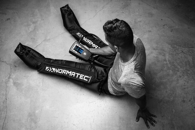 Man wearing Normatec compression leg sleeves during a recovery session — Normatec compression therapy available at Innovation Wellness in Early, Texas